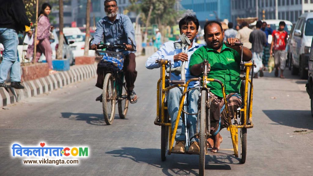 two disabled persons riding in a hand-driven tricycle. benchmark disability